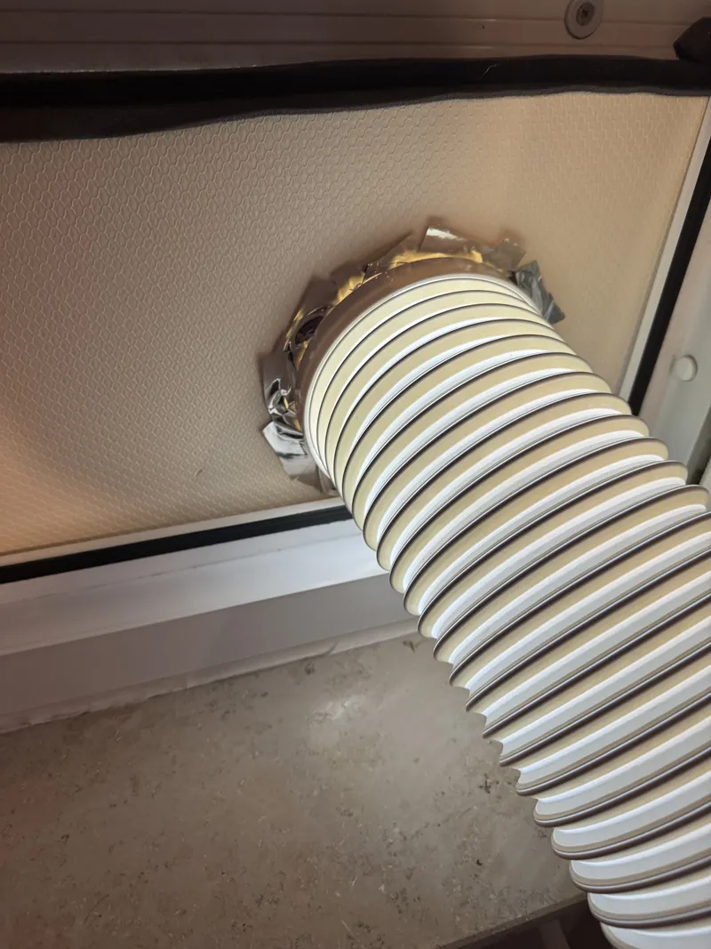 Detail of the sealed rim where the panel meets the frame, hose entering through the taped collar