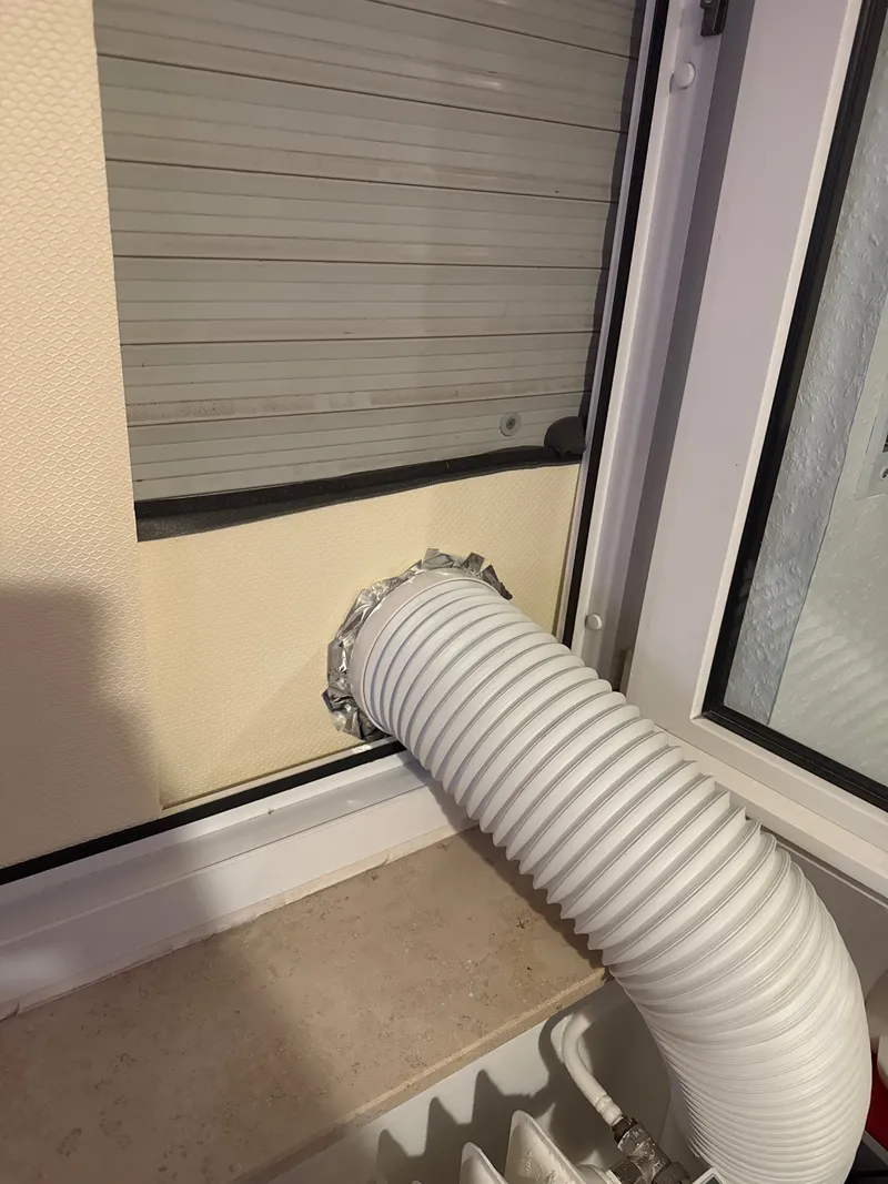 Close-up of the hose passing through the foil-taped hole in the XPS panel